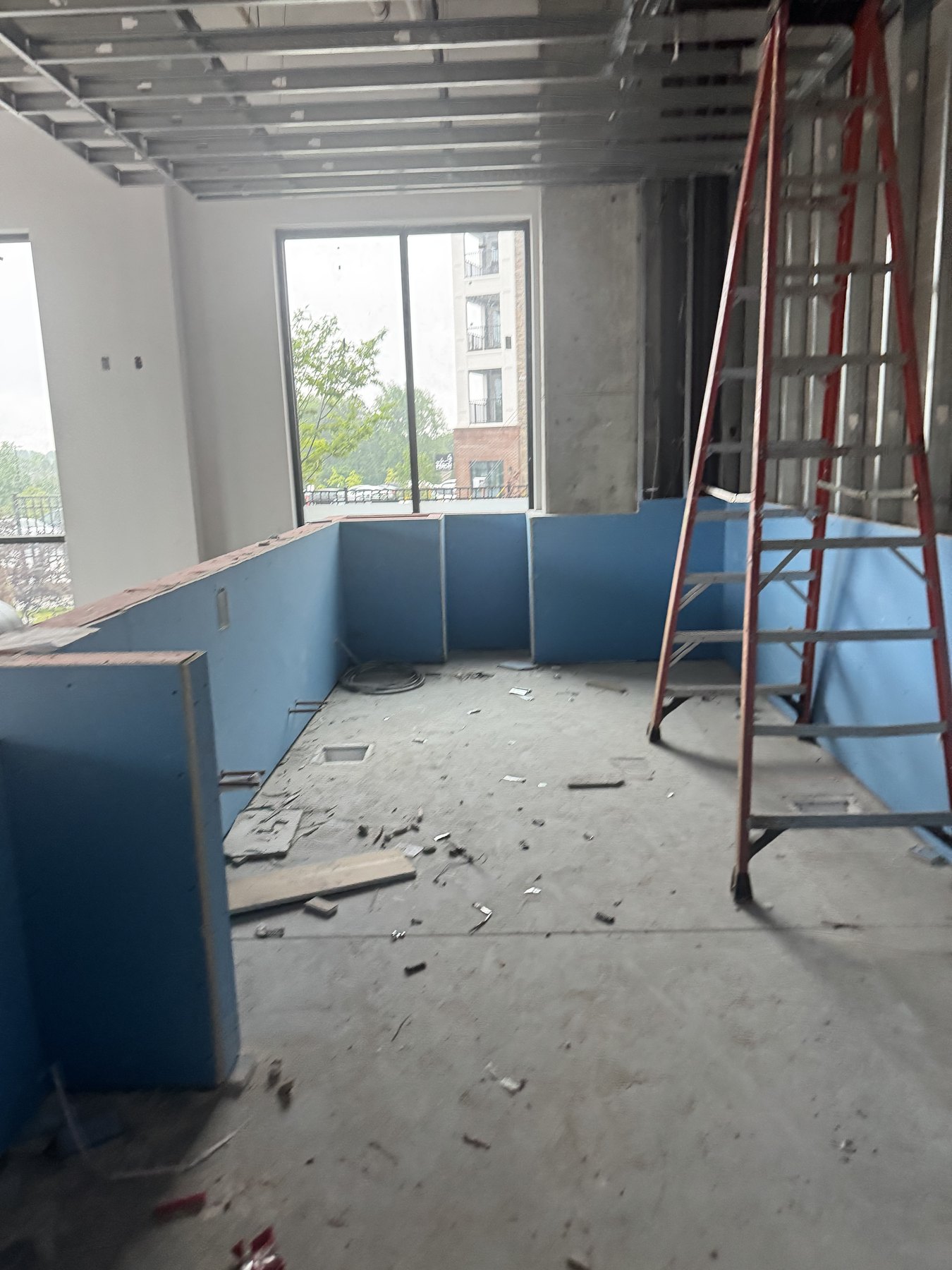 Updated construction photo of blue counter framing and a ladder