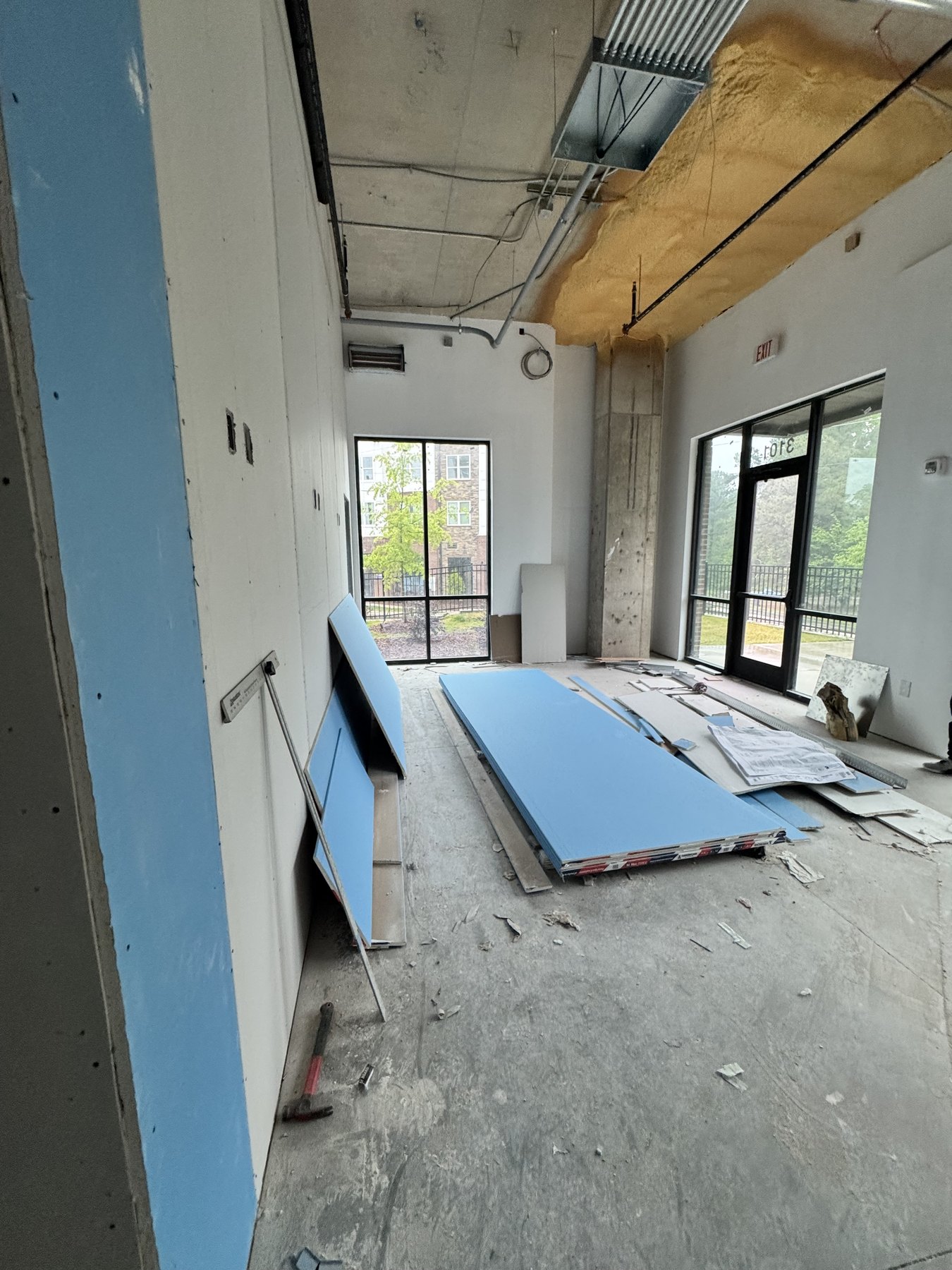 Updated construction photo of the back room with windows and materials